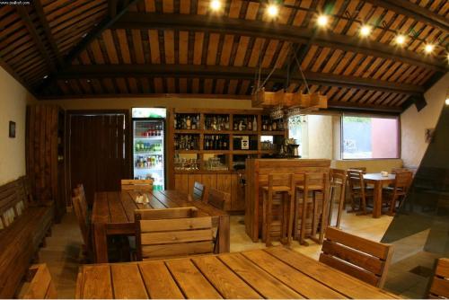 a restaurant with wooden tables and chairs and a bar at Savaneti Eco Hotel in Tʼelavi