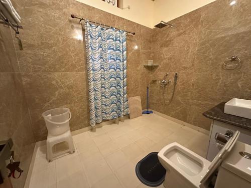 a bathroom with a shower and a toilet and a sink at Highfield Villa in Kanatal