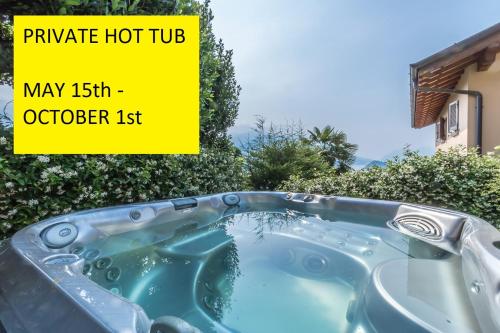 a bath tub with water in it with the words private hot tub may at Il Borgo Apartment Menaggio in Menaggio
