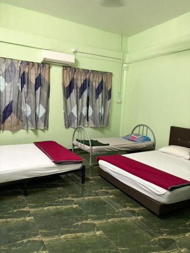a room with three beds and a window at De JITRA 2 HOMESTAY in Jitra