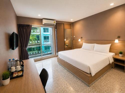 a bedroom with a large bed and a window at The Fifth Residence in Bangkok
