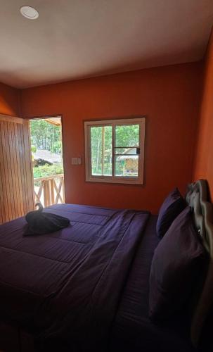 a bedroom with a large bed with a window at Farm Bungalow in Ao Nam Mao