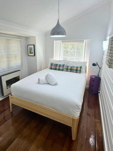 a bedroom with a large white bed with a fireplace at Blackheath Nook in Blackheath