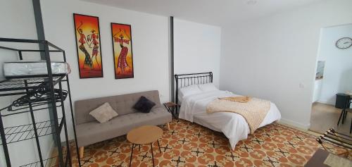 a living room with a couch and a bed at HDEZfalcon in Las Lagunas