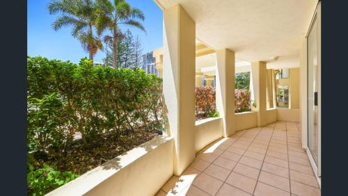 an empty hallway of a house with palm trees at Palazzo Colonnades in Gold Coast