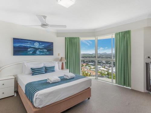 a bedroom with a large bed and a large window at Burleigh Surf Apartments in Gold Coast