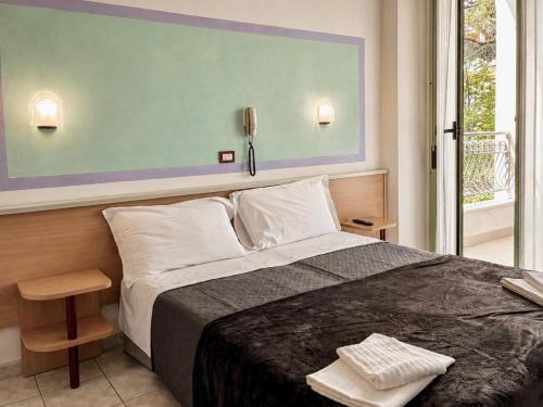 a bedroom with a bed and a phone on the wall at Hotel Dover Rooms & Coffee Adults Friendly in Cervia