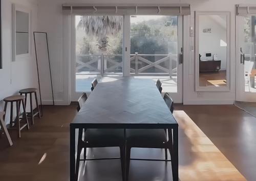 a dining room with a black table and chairs at jfハウス - カフェ併設の一棟貸切で楽しむプライベートステイ - サーフポイントまで徒歩5分 in Ichinomiya
