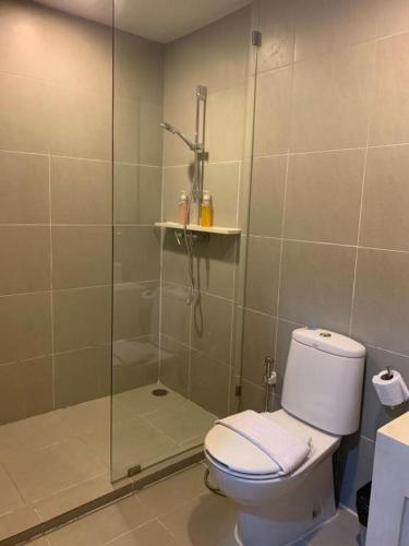 a bathroom with a shower and a toilet with a glass door at บ้านแสนสุขคอนโดติดทะเล By Nichahome in Hua Hin