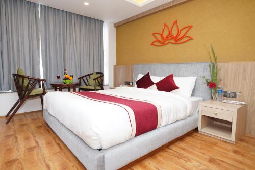 a bedroom with a large white bed with red pillows at Lotus Shines & Amenities in Manamaiju