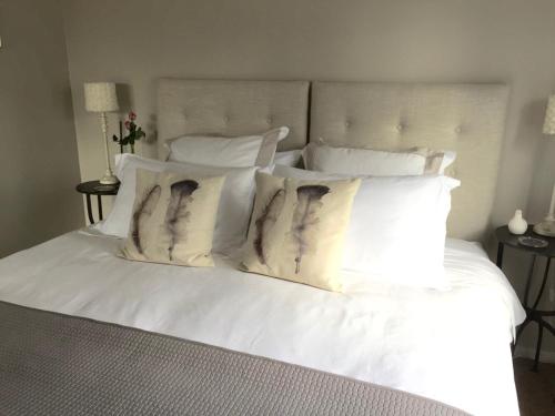 a bed with white sheets and pillows on it at Lodore Lodge in Kerikeri