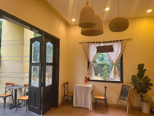 a room with a table and chairs and a window at Homestay Mẹ Mít in Cu Chi