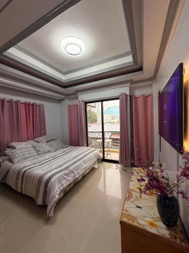 a bedroom with a bed and a large window at Rose Haven Staycation Panabo in Panabo