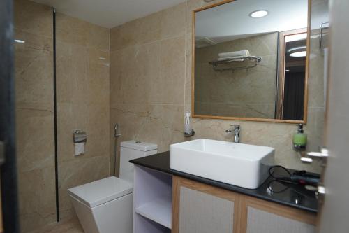 a bathroom with a sink and a toilet and a mirror at Lotus Shines & Amenities in Manamaiju