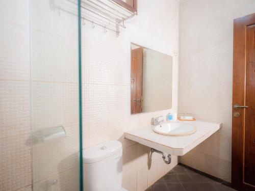 a bathroom with a toilet and a sink and a mirror at Grand Pujon View in Songgoriti