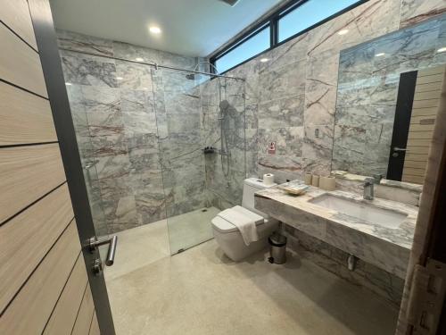 a bathroom with a toilet and a sink and a shower at Mango Tree Resort in Chiang Mai