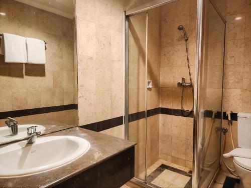 a bathroom with a sink and a shower at Olympic Hotel Jakarta in Jakarta