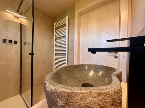 a large stone tub in a bathroom with a shower at Die Tinys - Ferienhäuser am Attersee in Nussdorf am Attersee
