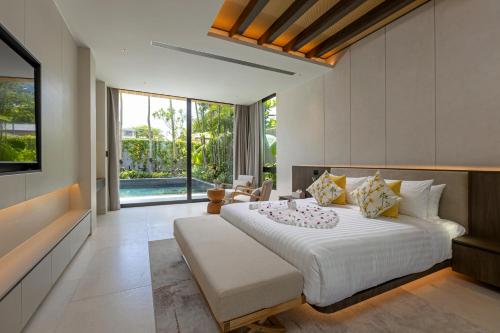 a bedroom with a large bed and a large window at Layana Residence in Layan Beach