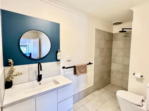 a bathroom with a white sink and a mirror at Sails Motel Geraldton in Geraldton