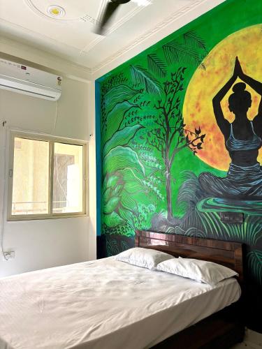 a bedroom with a wall with a painting of a woman sitting in a yoga pose at Mountain View Terrace Room Upper Tapovan in Rishīkesh