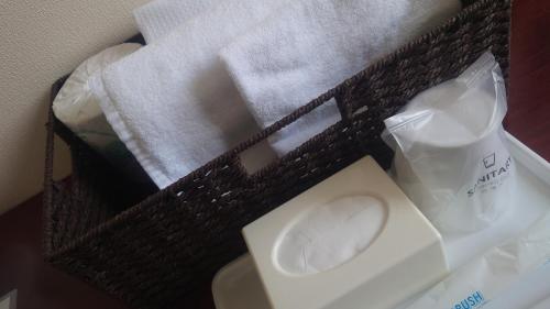a basket with a toilet and some towels at ビジネスホテル圭 in Kimiidera