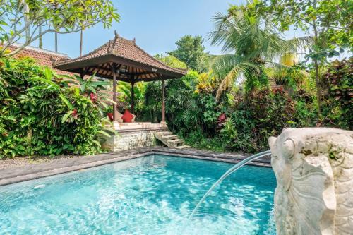 a swimming pool with a water fountain in a yard at Bali Dream Garden - Tropical Escape with Pool & Spa in Ubud