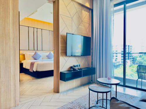 a hotel room with a bed and a tv at One Residence Hotel & Apartment in Phnom Penh