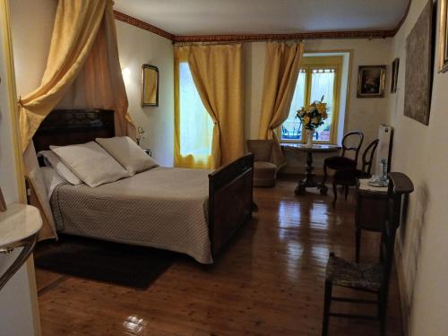 a bedroom with a bed and a table and a window at Le Chateau de Prauthoy in Prauthoy