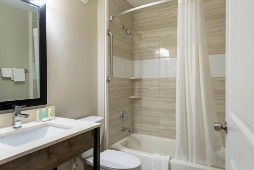 a bathroom with a sink and a toilet and a tub at Quality Inn Mishawaka - South Bend in Mishawaka