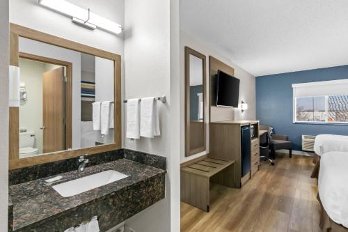 a hotel room with a sink and a bedroom at Quality Inn Neosho in Neosho