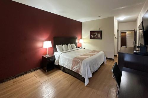 a hotel room with a bed and two lamps at Econo Lodge Inn & Suites in Monee