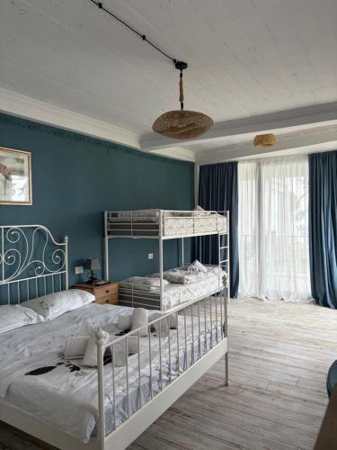 ein Schlafzimmer mit zwei Etagenbetten und einer blauen Wand in der Unterkunft Mana-Mana in Grigoleti