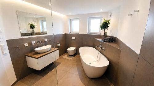 a bathroom with a tub and a sink and a toilet at Apartment Ihm in Memmingen