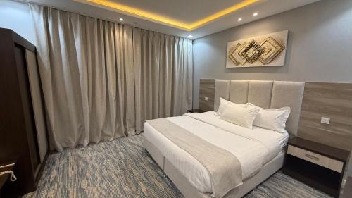 a bedroom with a large bed and a large window at Qimam Park Abha 2 in Abha