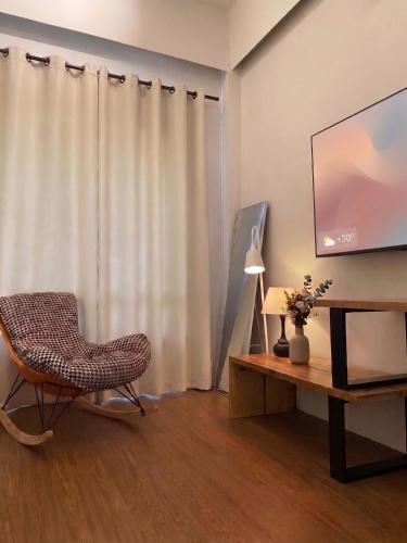a living room with a chair and a flat screen tv at Centerpoint Koh Phangan New in Thong Sala