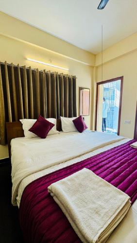 a bedroom with a large bed with red and white pillows at Hotel SK Temple View in Tiruvannāmalai