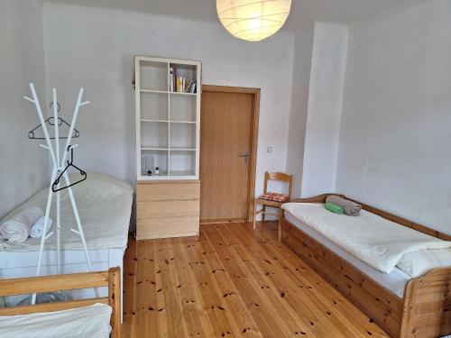 a bedroom with two beds and a glass table at Helles geteiltes Mehrbettzimmer in Leipzig