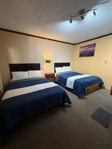 a bedroom with two beds with blue and white sheets at Hotel Santa Fe in Chignahuapan