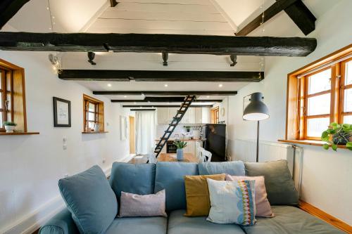 a living room with a blue couch with pillows at Romantic Nights Under The Thatched Roof in Scharnebeck