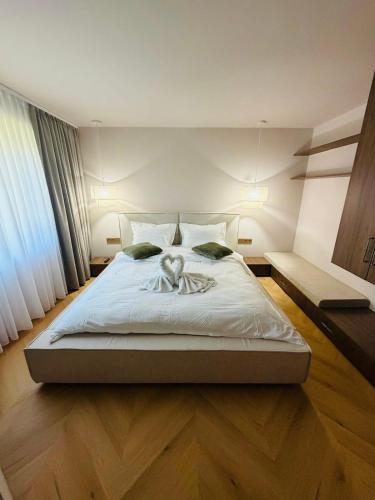 a bedroom with a large bed with white sheets at Vega House Luxury & Relax in Orşova