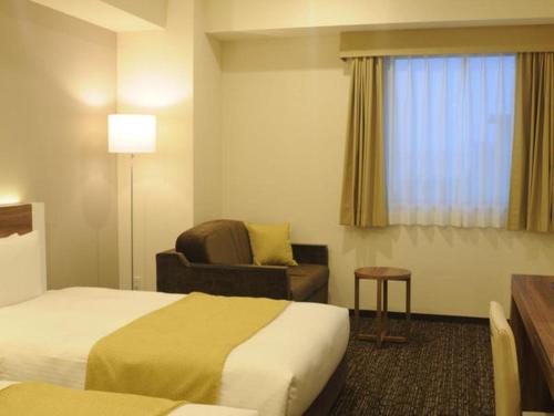 מיטה או מיטות בחדר ב-Hotel Sunroute Kumagaya Station
