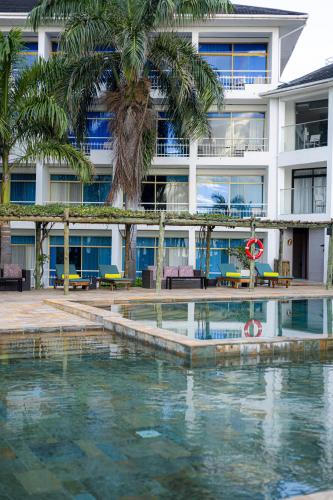 a hotel with a swimming pool in front of a building at Giraffe Beach Hotel in Dar es Salaam
