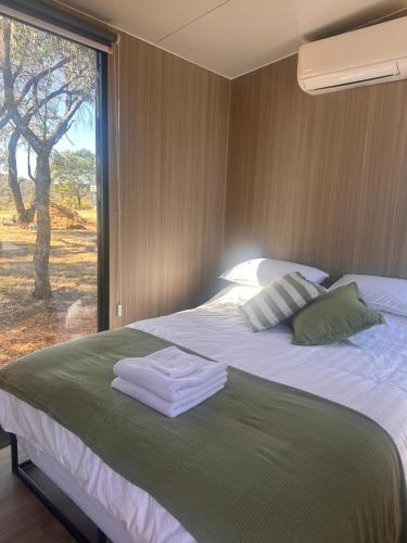 a bedroom with a large bed with towels on it at Tallarook Hilltop Tiny House 2 by Tiny Away in Tallarook