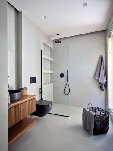 a bathroom with a black toilet and a glass shower at Eos Villa in Drios