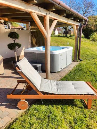a lounge chair and a tub in a backyard at KICIKLA Fire & Wine in Nagybakónak