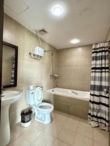 a bathroom with a toilet and a sink and a tub at Ace Penzionne by Hiverooms in Pajo