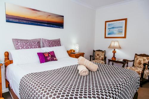 a bedroom with a large bed and two chairs at Coffs Jetty BnB in Coffs Harbour