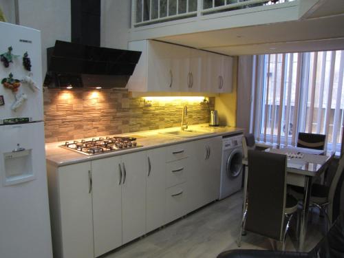 eine Küche mit Herd oberer Ofen neben einem Tisch in der Unterkunft Inna`s Studio in Tbilisi City