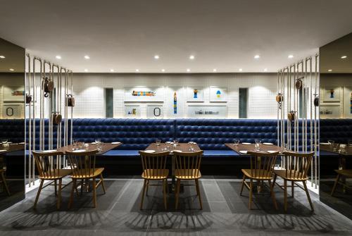 a restaurant with tables and chairs and a blue bench at The Port Hotel in Visakhapatnam